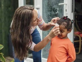 Mãe faz um curativo em criança que bateu a cabeça