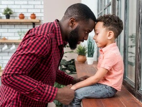 pai conversa com o filho sentado na beirada da janela