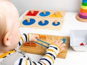 Bebê brincando com objetos lúdicos que trabalham a coordenação motora fina