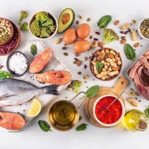 Uma vista aérea de diversos alimentos dispostos sobre uma superfície clara, organizados em tigelas de madeira, tábuas de corte e pequenos recipientes. Uma vista aérea de diversos alimentos dispostos sobre uma superfície clara, organizados em tigelas de madeira, tábuas de corte e pequenos recipientes.