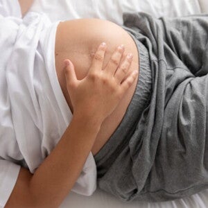 gestante deitada com a mão na barriga proeminente de gestação avançada gestante deitada com a mão na barriga proeminente de gestação avançada