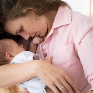 Mãe segurando e ninando o filho recém nascido Mãe segurando e ninando o filho recém nascido