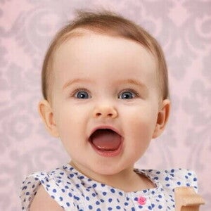 Bebê com a boca aberta sob um fundo rosa Bebê com a boca aberta sob um fundo rosa