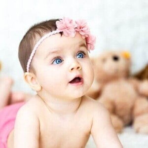 Um bebê deitado com a boca aberta, com ursos de pelúcia ao fundo. Um bebê deitado com a boca aberta, com ursos de pelúcia ao fundo.